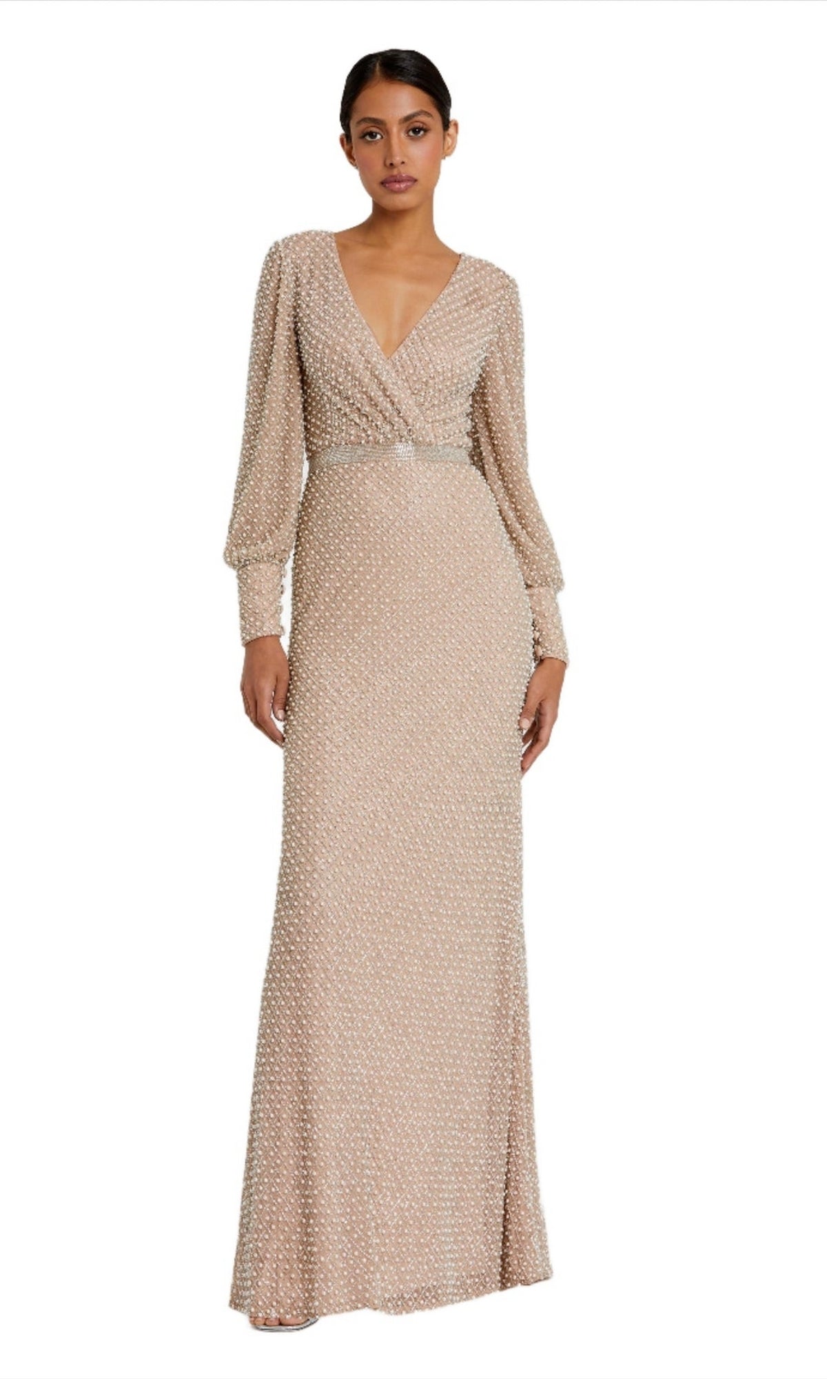 A woman wears the Mac Duggal 10062—an ivory formal gown with long sleeves, a deep V-neckline, beaded detailing, and intricate textured patterns.
